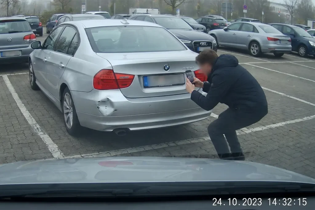 Parkunfall dokumentieren – Person fotografiert Unfallschaden auf Parkplatz