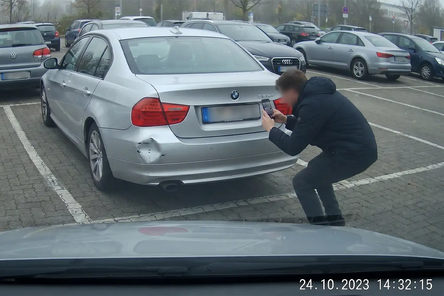 Parkunfall dokumentieren – Person fotografiert Unfallschaden auf Parkplatz